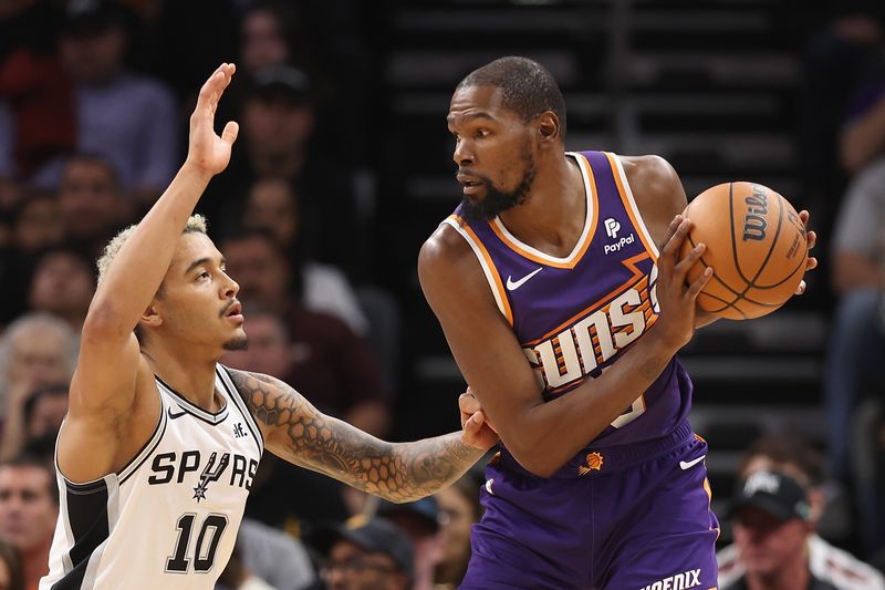 PHOENIX, ARIZONA - NOVEMBER 02: Kevin Durant #35 of the Phoenix Suns handles the ball against Jeremy Sochan #10 of the San Antonio Spurs during the first half of the NBA game at Footprint Center on November 02, 2023 in Phoenix, Arizona. NOTE TO USER: User expressly acknowledges and agrees that, by downloading and or using this photograph, User is consenting to the terms and conditions of the Getty Images License Agreement.  (Photo by Christian Petersen/Getty Images)