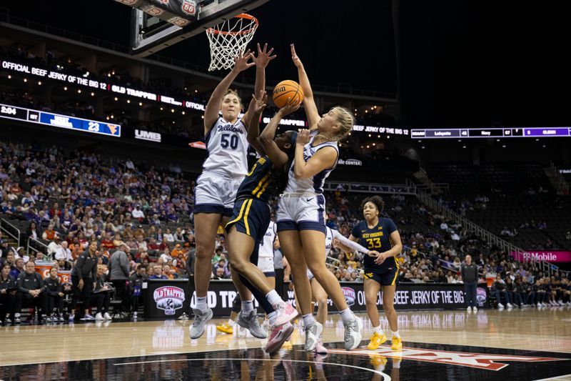 Mar 9, 2024; Kansas City, MO, USA; West Virginia Mountaineers guard Jayla Hemingway (00) shoots the ball while defended nay Kansas State Wildcats center Ayoka Lee (50) and guard Serena Sundell (4) during the first half at T-Mobile Center. Mandatory Credit: Amy Kontras-USA TODAY Sports