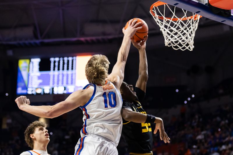 Feb 28, 2024; Gainesville, Florida, USA; Florida Gators forward Thomas Haugh (10) blocks a layup from Missouri Tigers guard Sean East II (55) during the first half at Exactech Arena at the Stephen C. O'Connell Center. Mandatory Credit: Matt Pendleton-USA TODAY Sports