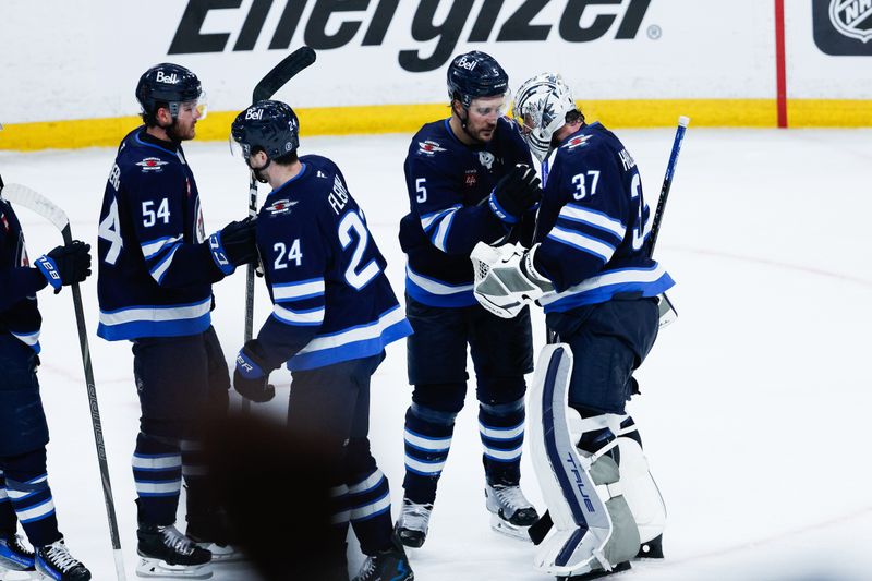 May 15, 2025; Winnipeg, Manitoba, CAN; Winnipeg Jets goalie Connor Hellebuyck (37) is congratulated by his teammates on their win against the Dallas Stars at the end of the third period in game five of the second round of the 2025 Stanley Cup Playoffs at Canada Life Centre. Mandatory Credit: Terrence Lee-Imagn Images
