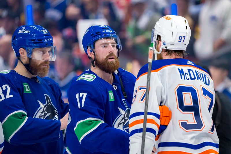 May 20, 2024; Vancouver, British Columbia, CAN; Vancouver Canucks defenseman Ian Cole (82) and defenseman Filip Hronek (17) shake hands with Edmonton Oilers forward Connor McDavid (97) after the Edmonton victory in game seven of the second round of the 2024 Stanley Cup Playoffs at Rogers Arena. Mandatory Credit: Bob Frid-USA TODAY Sports