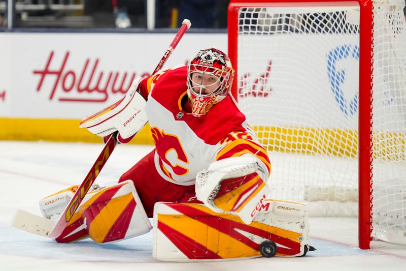 Nov 29, 2024; Columbus, Ohio, USA;  Calgary Flames goaltender Dustin Wolf (32) tosses the puck after making a save against the Columbus Blue Jackets in the second period at Nationwide Arena. Mandatory Credit: Aaron Doster-Imagn Images