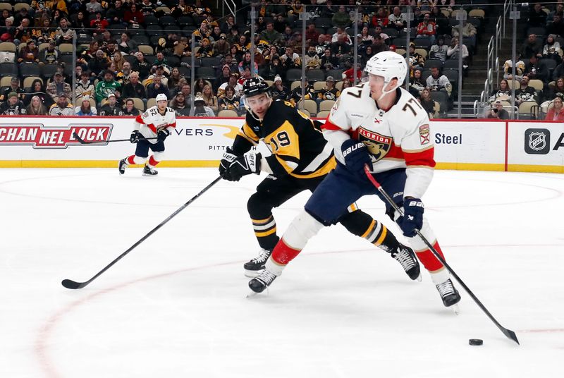 Feb 14, 2024; Pittsburgh, Pennsylvania, USA; Florida Panthers defenseman Niko Mikkola (77) handles the puck against Pittsburgh Penguins right wing Reilly Smith (19) during the third period at PPG Paints Arena. Florida won 5-2. Mandatory Credit: Charles LeClaire-USA TODAY Sports