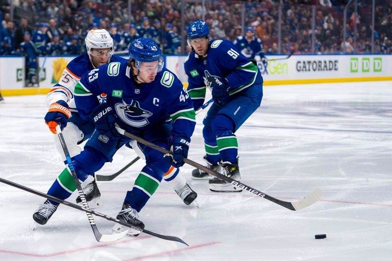 Oct 4, 2024; Vancouver, British Columbia, CAN; Edmonton Oilers defenseman Darnell Nurse (25) stick checks Vancouver Canucks defenseman Quinn Hughes (43) during the third period at Rogers Arena. Mandatory Credit: Bob Frid-Imagn Images