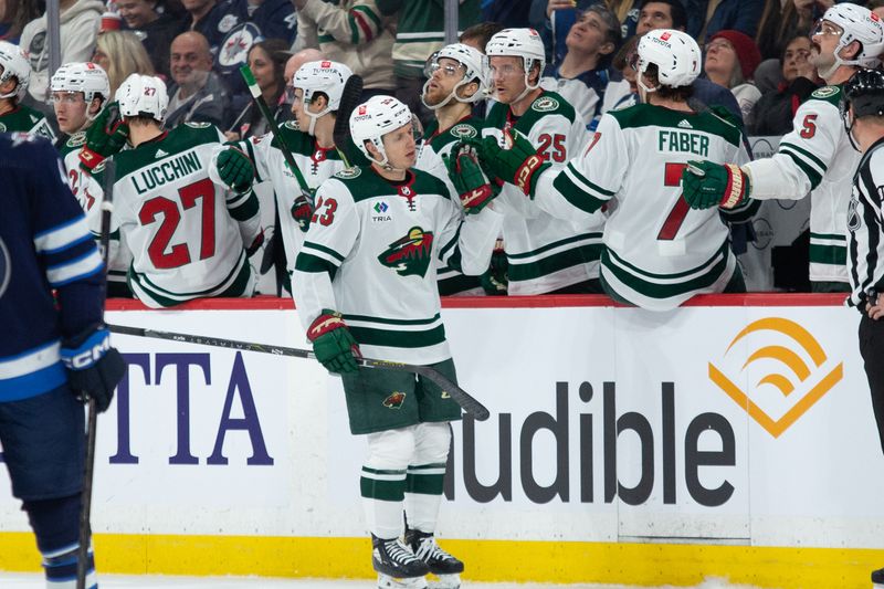 Feb 20, 2024; Winnipeg, Manitoba, CAN; Minnesota Wild forward Marco Rossi(23) is congratulated by his team mates on his goal against the Winnipeg Jets during the second period at Canada Life Centre. Mandatory Credit: Terrence Lee-USA TODAY Sports