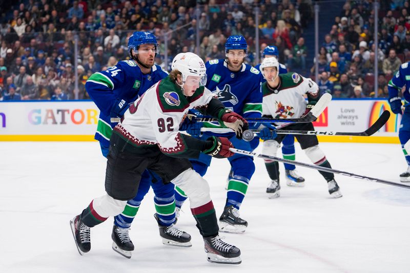 Jan 18, 2024; Vancouver, British Columbia, CAN; Vancouver Canucks forward Pius Suter (24) and Arizona Coyotes forward Logan Cooley (92) battle for the loose puck in the first period at Rogers Arena. Mandatory Credit: Bob Frid-USA TODAY Sports