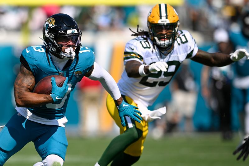 Jacksonville Jaguars' Christian Kirk runs past Green Bay Packers' Xavier McKinney after a catch during the first half of an NFL football game Sunday, Oct. 27, 2024, in Jacksonville, Fla. (AP Photo/Phelan M. Ebenhack)