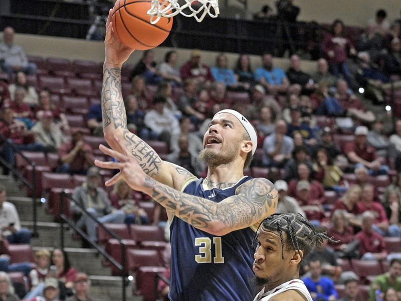 Jan 18, 2025; Tallahassee, Florida, USA; Georgia Tech Yellowjackets forward Duncan Powell (31) shoots the ball against Florida State Seminoles guard Justin Thomas (25) during the second half at Donald L. Tucker Center. Mandatory Credit: Robert Myers-Imagn Images