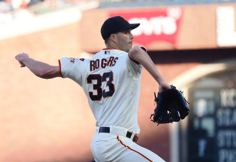 Aug 27, 2023; San Francisco, California, USA; San Francisco Giants relief pitcher Taylor Rogers (33) pitches the ball against the Atlanta Braves during the eighth inning at Oracle Park. Mandatory Credit: Kelley L Cox-USA TODAY Sports