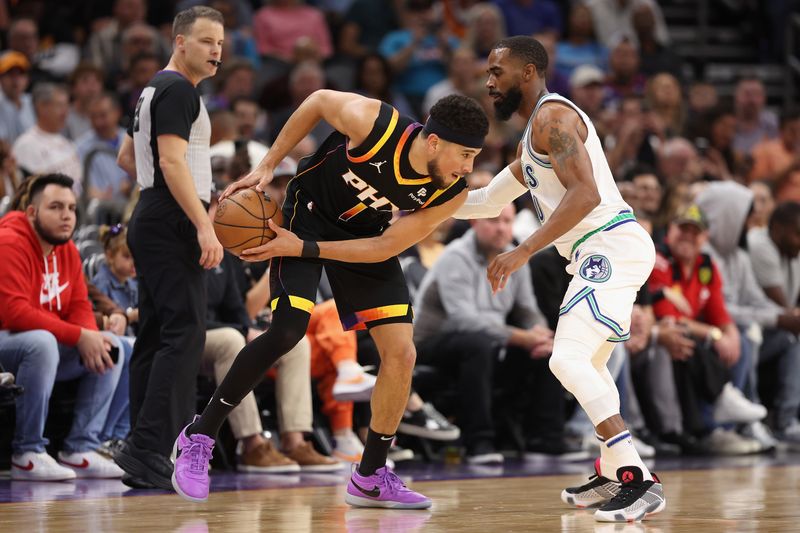 PHOENIX, ARIZONA - NOVEMBER 15: Devin Booker #1 of the Phoenix Suns handles the ball against Mike Conley #10 of the Minnesota Timberwolves during the first half of the NBA game at Footprint Center on November 15, 2023 in Phoenix, Arizona. The Suns defeated the Timberwolves 133-115. NOTE TO USER: User expressly acknowledges and agrees that, by downloading and or using this photograph, User is consenting to the terms and conditions of the Getty Images License Agreement.  (Photo by Christian Petersen/Getty Images)