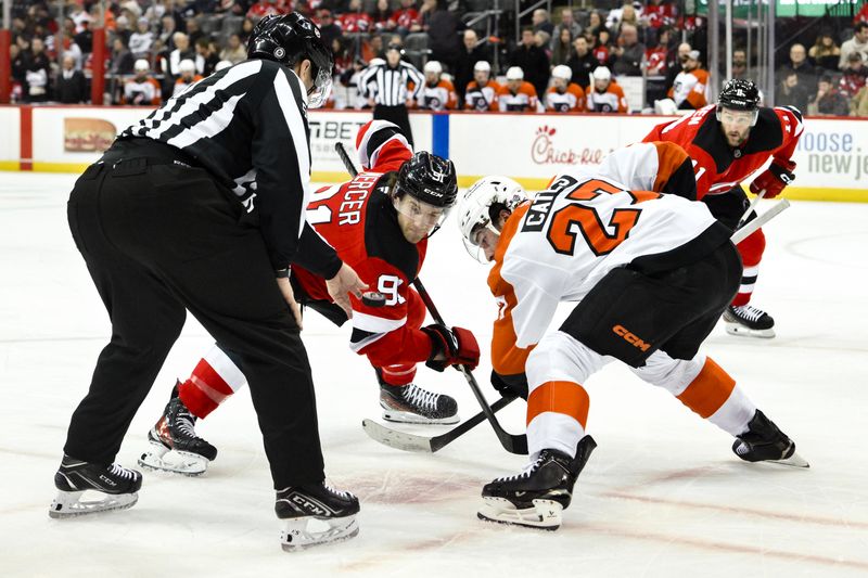 Jan 29, 2025; Newark, New Jersey, USA; New Jersey Devils center Dawson Mercer (91) faces off against Philadelphia Flyers left wing Noah Cates (27) during the first period at Prudential Center. Mandatory Credit: John Jones-Imagn Images