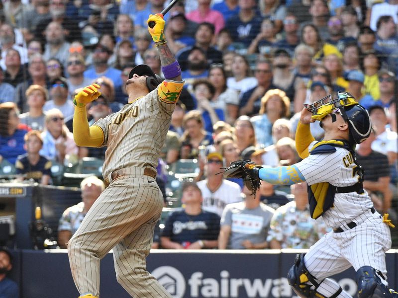 Aug 27, 2023; Milwaukee, Wisconsin, USA; San Diego Padres third baseman Manny Machado (13) pops the ball up as Milwaukee Brewers catcher William Contreras (24) looks for it in the seventh inning at American Family Field. Mandatory Credit: Michael McLoone-USA TODAY Sports