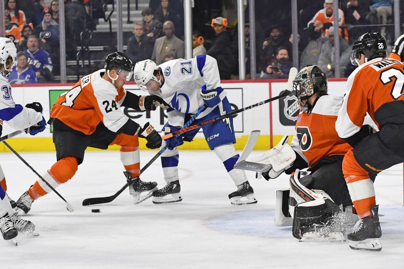 Feb 27, 2024; Philadelphia, Pennsylvania, USA; Tampa Bay Lightning center Brayden Point (21) and Philadelphia Flyers defenseman Nick Seeler (24) battle for the puck in front of goaltender Samuel Ersson (33) during the second period at Wells Fargo Center. Mandatory Credit: Eric Hartline-USA TODAY Sports