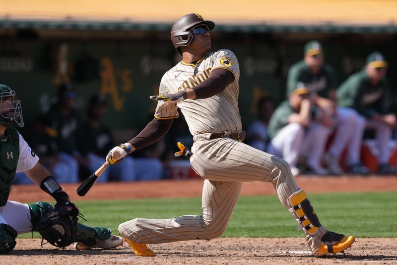 Sep 17, 2023; Oakland, California, USA; San Diego Padres left fielder Juan Soto (22) hits a grand slam home run against the Oakland Athletics during the eighth inning at Oakland-Alameda County Coliseum. Mandatory Credit: Darren Yamashita-USA TODAY Sports