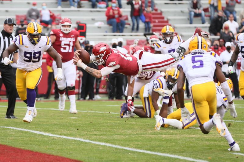 Nov 21, 2020; Fayetteville, Arkansas, USA; Arkansas Razorbacks quarterback Feleipe Franks (13) dives for a touchdown as LSU Tigers defensive lineman Jaquelin Roy (99) defends during the second quarter at Donald W. Reynolds Razorback Stadium. Mandatory Credit: Nelson Chenault-USA TODAY Sports