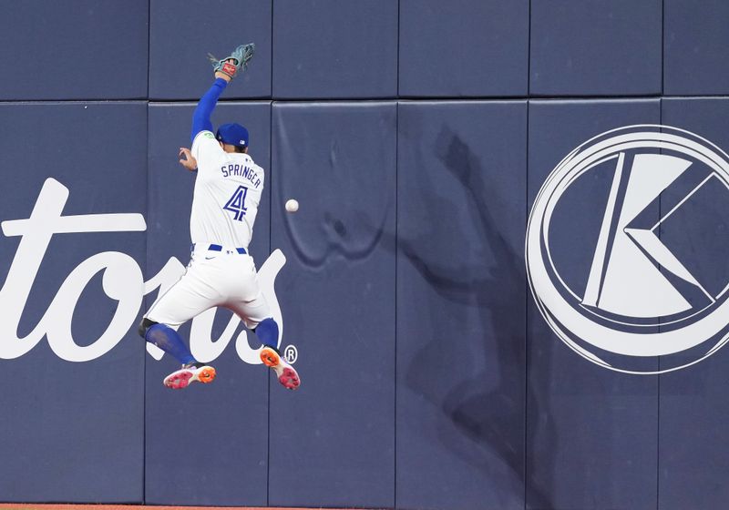 Jun 30, 2024; Toronto, Ontario, CAN; Toronto Blue Jays right fielder George Springer (4) tries to catch a fly ball  against the New York Yankees during the fifth inning at Rogers Centre. Mandatory Credit: Nick Turchiaro-USA TODAY Sports