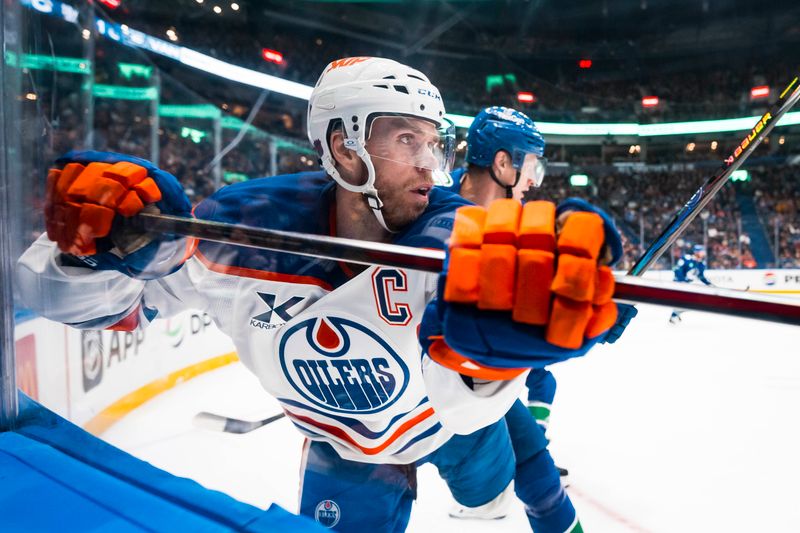 Oct 3, 2025; Vancouver, British Columbia, CAN; Vancouver Canucks defenseman Tyler Myers (57) checks Edmonton Oilers forward Connor McDavid (97) in the second period at Rogers Arena. Mandatory Credit: Bob Frid-Imagn Images