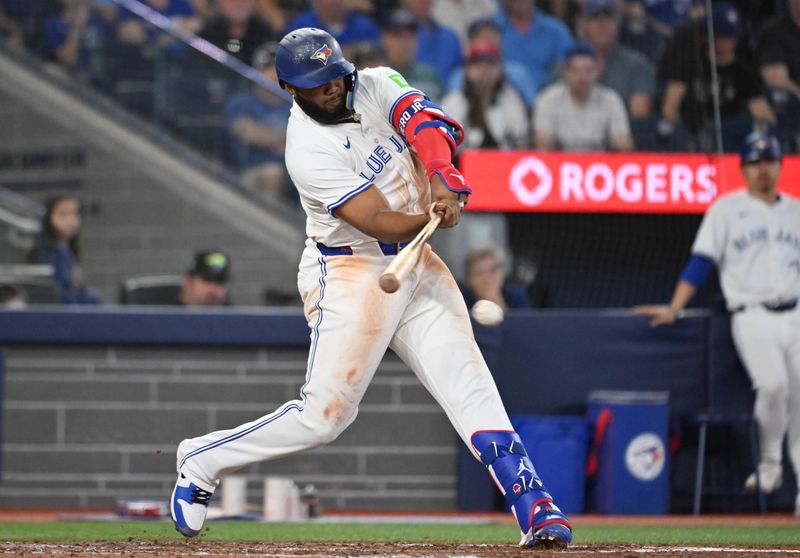 Jun 4, 2025; Toronto, Ontario, CAN;  Toronto Blue Jays first baseman Vladimir Guerrero Jr. (27) hits a single against the Philadelphia Phillies in the ninth inning at Rogers Centre. Mandatory Credit: Dan Hamilton-Imagn Images