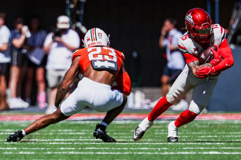 Oct 4, 2025; Tucson, Arizona, USA; Arizona Wildcats wide receiver Luke Wysong (15) protects the football against  Oklahoma State Cowboys safety Kenneth Harris (23) during the second quarter at Arizona Stadium. Mandatory Credit: Aryanna Frank-Imagn Images