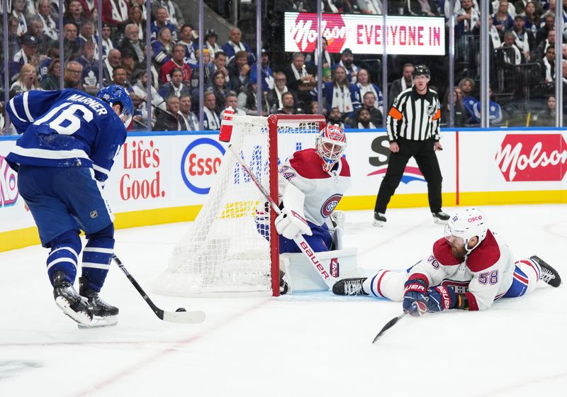 Oct 11, 2023; Toronto, Ontario, CAN; Toronto Maple Leafs right wing Mitchell Marner (16) controls the puck at the side of the net as Montreal Canadiens defenseman David Savard (58) tries to defend during the third period at Scotiabank Arena. Mandatory Credit: Nick Turchiaro-USA TODAY Sports