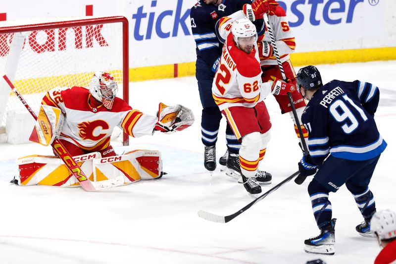 Apr 4, 2024; Winnipeg, Manitoba, CAN; Calgary Flames goaltender Dustin Wolf (32) makes a gloves save on a Winnipeg Jets center Cole Perfetti (91) shot in the third period at Canada Life Centre. Mandatory Credit: James Carey Lauder-USA TODAY Sports