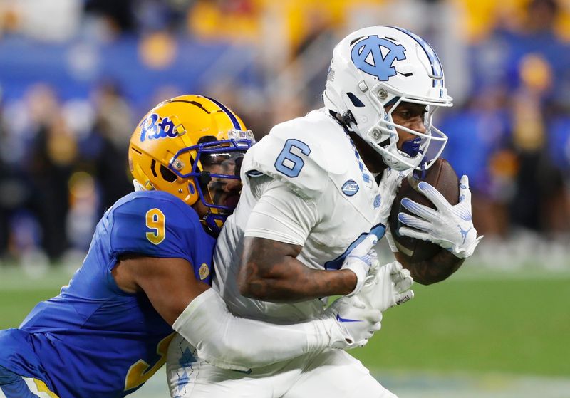 Sep 23, 2023; Pittsburgh, Pennsylvania, USA; North Carolina Tar Heels wide receiver Nate McCollum (6) secures a catch against Pittsburgh Panthers defensive back A.J. Woods (9) during the third quarter at Acrisure Stadium. The Tar Heels won 41-24. Mandatory Credit: Charles LeClaire-USA TODAY Sports