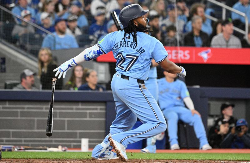 Apr 29, 2024; Toronto, Ontario, CAN; Toronto Blue Jays first baseman Vladimir Guerrero Jr. (27) hits an RBI double against the Kansas City Royals in the sixth inning at Rogers Centre. Mandatory Credit: Dan Hamilton-USA TODAY Sports