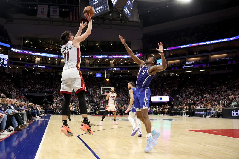 SACRAMENTO, CALIFORNIA - FEBRUARY 26: Jaime Jaquez Jr. #11 of the Miami Heat shoots over De'Aaron Fox #5 of the Sacramento Kings in the second half at Golden 1 Center on February 26, 2024 in Sacramento, California. NOTE TO USER: User expressly acknowledges and agrees that, by downloading and or using this photograph, User is consenting to the terms and conditions of the Getty Images License Agreement.  (Photo by Ezra Shaw/Getty Images)