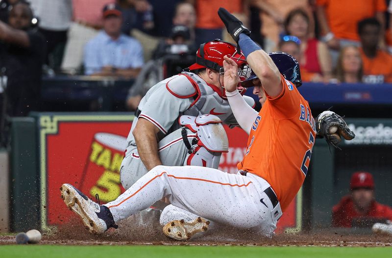 Apr 30, 2023; Houston, Texas, USA; Houston Astros third baseman Alex Bregman (2) slides safely to score a run as Philadelphia Phillies catcher J.T. Realmuto (10) attempts to apply a tag during the fifth inning at Minute Maid Park. Mandatory Credit: Troy Taormina-USA TODAY Sports