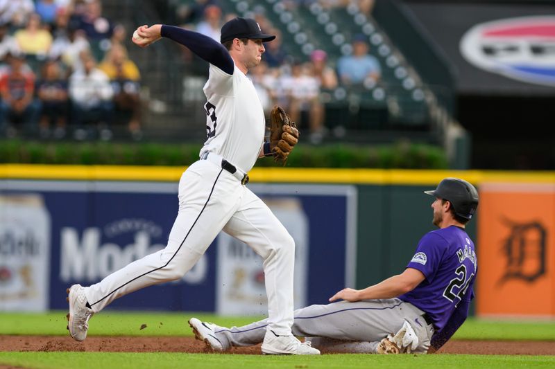 Sep 10, 2024; Detroit, Michigan, USA; Detroit Tigers second baseman Colt Keith (33) turns a double play over sliding Colorado Rockies third baseman Ryan McMahon (24) in the second inning at Comerica Park. Mandatory Credit: Lon Horwedel-Imagn Images