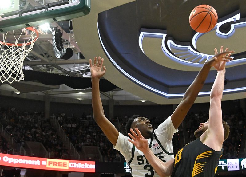 Feb 20, 2024; East Lansing, Michigan, USA;  Iowa Hawkeyes forward Ben Krikke (23) shoots past Michigan State Spartans forward Xavier Booker (34) during the first half at Jack Breslin Student Events Center. Mandatory Credit: Dale Young-USA TODAY Sports
