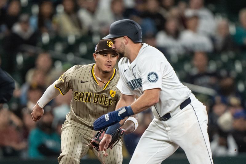 Sep 11, 2024; Seattle, Washington, USA;  San Diego Padres third baseman Manny Machado (13) tags out Seattle Mariners catcher Cal Raleigh (29) during the fifth inningat T-Mobile Park. Mandatory Credit: Stephen Brashear-Imagn Images