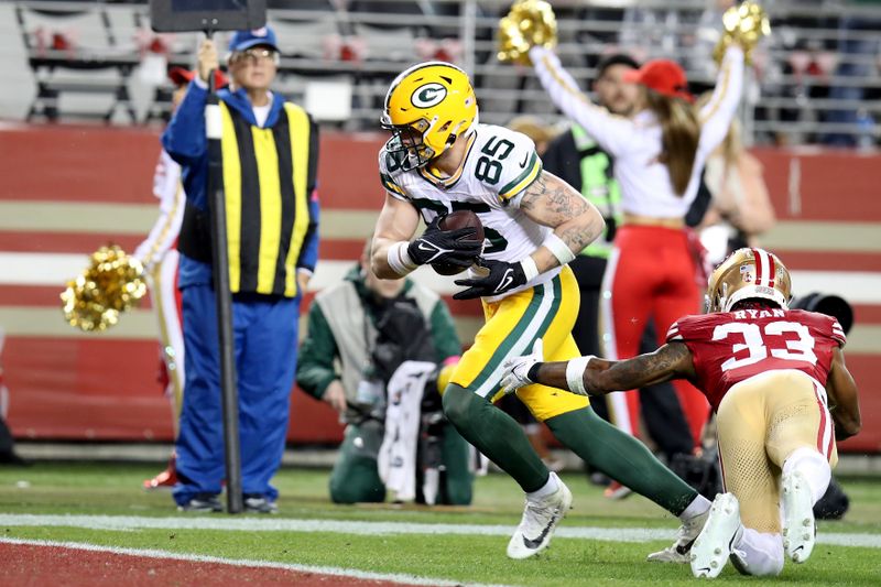 Green Bay Packers tight end Tucker Kraft (85) evades a tackle by San Francisco 49ers safety Logan Ryan (33) during an NFL divisional round playoff football game Saturday, Jan. 20, 2024, in Santa Clara. (AP Photo/Scot Tucker)