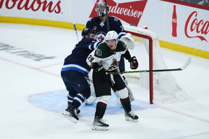 Jan 15, 2023; Winnipeg, Manitoba, CAN; Winnipeg Jets defenseman Neal Pionk (4) battles for position with Arizona Coyotes forward Barrett Hayton (29) during the third period at Canada Life Centre. Mandatory Credit: Terrence Lee-USA TODAY Sports