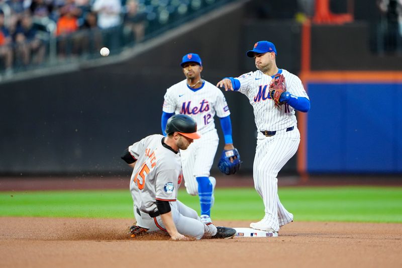 Aug 19, 2024; New York City, New York, USA; New York Mets second baseman Jose Iglesias (11) turns a double play with Baltimore Orioles left fielder Austin Slater (15) sliding into second base during the first inning at Citi Field. Mandatory Credit: Gregory Fisher-USA TODAY Sports