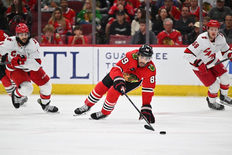 Apr 14, 2024; Chicago, Illinois, USA; Chicago Blackhawks forward Andreas Athanasiou (89) reaches back for the puck in the third period against the Carolina Hurricanes at United Center. Mandatory Credit: Jamie Sabau-USA TODAY Sports