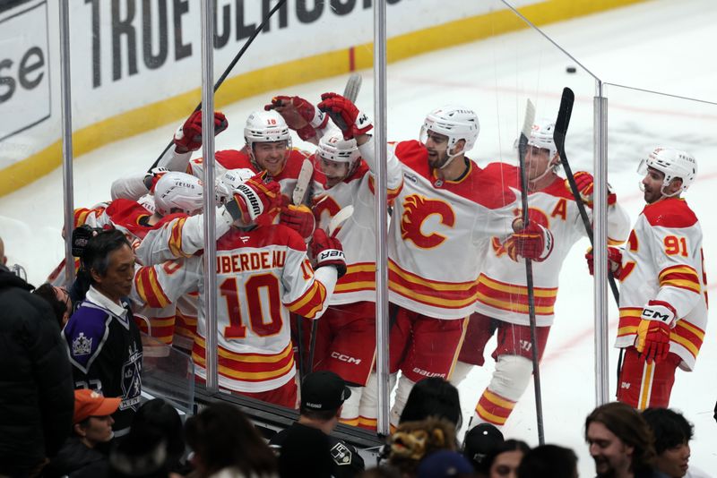 Dec 13, 2025; Los Angeles, California, USA;  Calgary Flames players celebrate after defeating the Los Angeles Kings in the overtime at Crypto.com Arena. Mandatory Credit: Kiyoshi Mio-Imagn Images