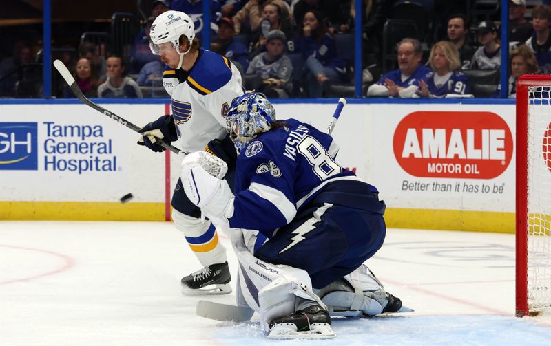 Dec 19, 2023; Tampa, Florida, USA; Tampa Bay Lightning goaltender Andrei Vasilevskiy (88) makes a save as St. Louis Blues looks on during the second period at Amalie Arena. Mandatory Credit: Kim Klement Neitzel-USA TODAY Sports