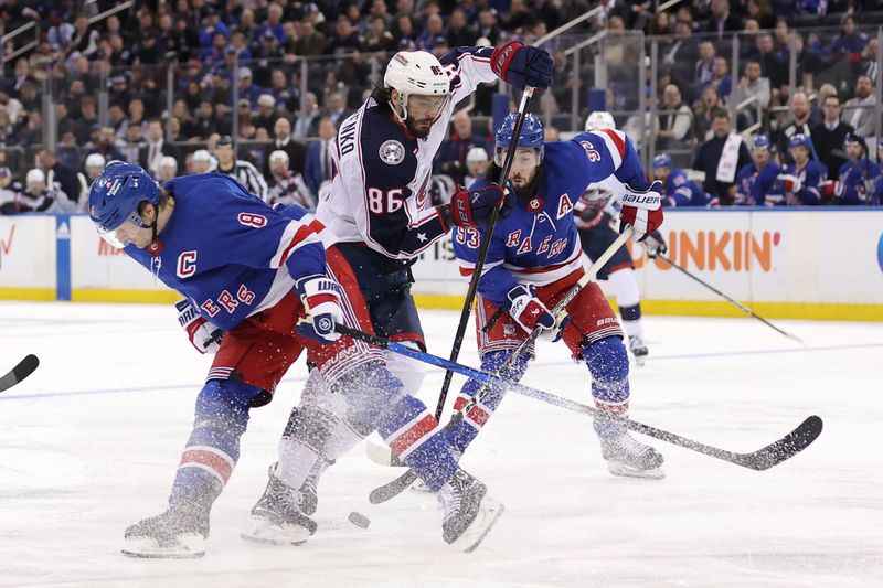 Feb 28, 2024; New York, New York, USA; Columbus Blue Jackets right wing Kirill Marchenko (86) skates the puck between New York Rangers defenseman Jacob Trouba (8) and center Mika Zibanejad (93) during the third period at Madison Square Garden. Mandatory Credit: Brad Penner-USA TODAY Sports