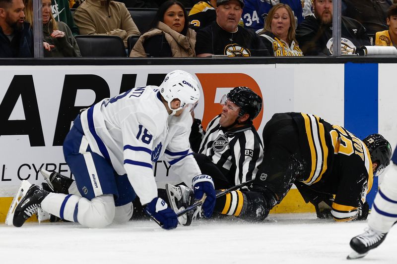 Oct 26, 2024; Boston, Massachusetts, USA; lLnesman Matt MacPherson (83)  gets caught in a collision between Toronto Maple Leafs center Steven Lorentz (18) and Boston Bruins defenseman Charlie McAvoy (73) during the third period at TD Garden. Mandatory Credit: Winslow Townson-Imagn Images