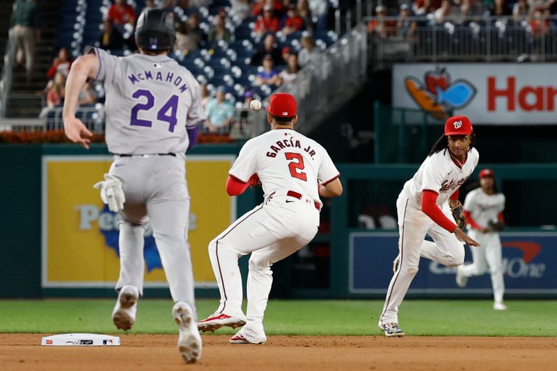 Aug 20, 2024; Washington, District of Columbia, USA; Washington Nationals shortstop CJ Abrams (5) makes a toss to Nationals second baseman Luis García Jr. (2) at second base for an inning ending force out ahead of a slide by Colorado Rockies third baseman Ryan McMahon (24) during the seventh inning at Nationals Park. Mandatory Credit: Geoff Burke-USA TODAY Sports