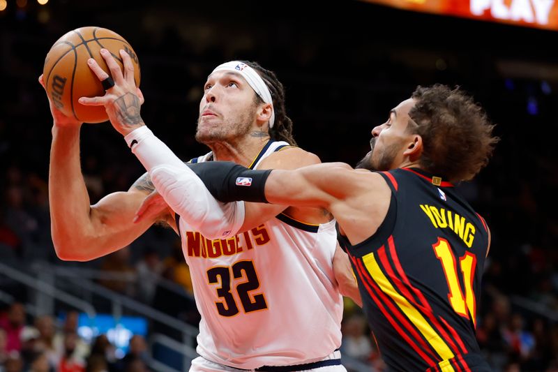 ATLANTA, GEORGIA - DECEMBER 08: Aaron Gordon #32 of the Denver Nuggets is fouled by Trae Young #11 of the Atlanta Hawks during the first quarter at State Farm Arena on December 8, 2024 in Atlanta, Georgia. NOTE TO USER: User expressly acknowledges and agrees that, by downloading and or using this photograph, User is consenting to the terms and conditions of the Getty Images License Agreement. (Photo by Todd Kirkland/Getty Images)