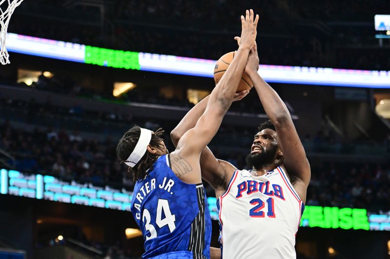 ORLANDO, FLORIDA - JANUARY 19: Joel Embiid #21 of the Philadelphia 76ers draws the foul from Wendell Carter Jr. #34 of the Orlando Magic in the first half of a game at Kia Center on January 19, 2024 in Orlando, Florida. NOTE TO USER: User expressly acknowledges and agrees that, by downloading and or using this photograph, User is consenting to the terms and conditions of the Getty Images License Agreement. (Photo by Julio Aguilar/Getty Images)