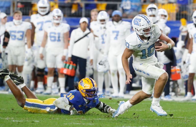 Sep 23, 2023; Pittsburgh, Pennsylvania, USA; North Carolina Tar Heels quarterback Drake Maye (10) runs the ball past Pittsburgh Panthers linebacker Kyle Louis (38) during the second quarter at Acrisure Stadium. Mandatory Credit: Charles LeClaire-USA TODAY Sports