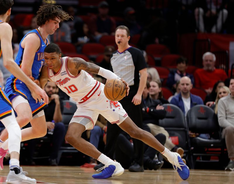 HOUSTON, TEXAS - DECEMBER 06: Jabari Smith Jr. #10 of the Houston Rockets drives against  Josh Giddey #3 of the Oklahoma City Thunder during the first half at Toyota Center on December 06, 2023 in Houston, Texas. (Photo by Carmen Mandato/Getty Images)