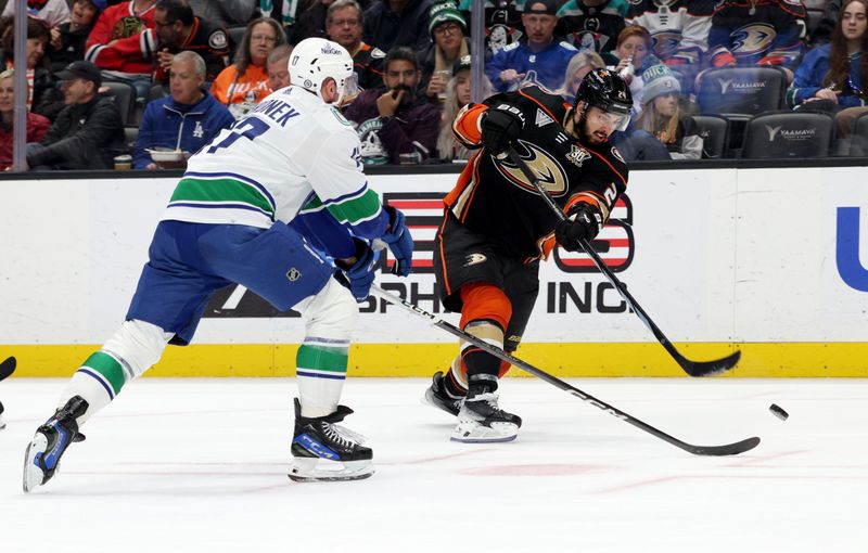 Mar 3, 2024; Anaheim, California, USA; Anaheim Ducks center Bo Groulx (24) shoots against Vancouver Canucks defenseman Filip Hronek (17) during the second period at Honda Center. Mandatory Credit: Jason Parkhurst-USA TODAY Sports