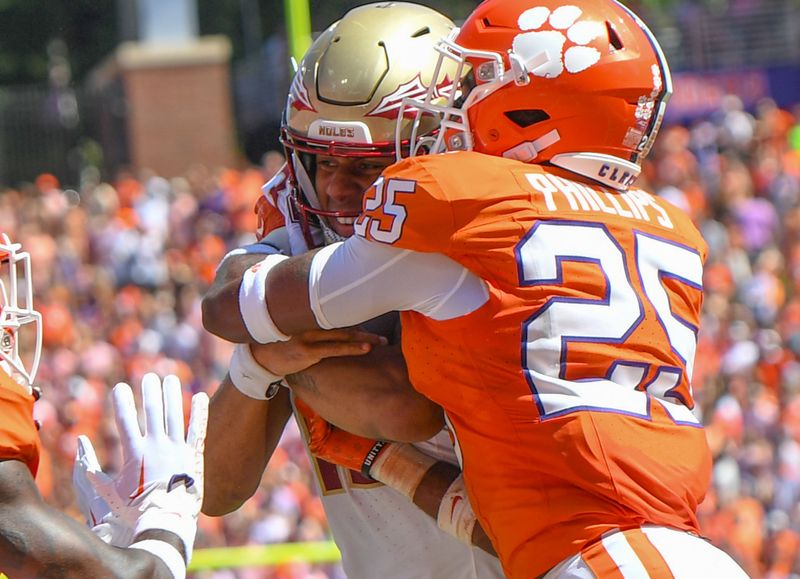 Sep 23, 2023; Clemson, South Carolina, USA; Florida State Seminoles quarterback Jordan Travis (13) scores against Clemson Tigers safety Jalyn Phillips (25) during the second quarter at Memorial Stadium. Mandatory Credit: Ken Ruinard-USA TODAY Sports