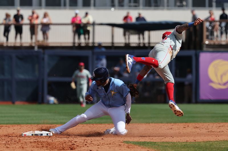 Feb 25, 2025; Port Charlotte, Florida, USA;  Tampa Bay Rays third baseman Christopher Morel (24) slides safely into second base against Philadelphia Phillies shortstop Edmundo Sosa (33) during the fourth inning at Charlotte Sports Park. Mandatory Credit: Kim Klement Neitzel-Imagn Images