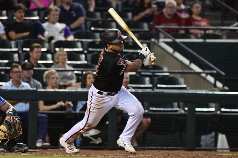 May 8, 2023; Phoenix, Arizona, USA;  Arizona Diamondbacks catcher Gabriel Moreno (14) hits an RBI single in the sixth inning against the Miami Marlins at Chase Field. Mandatory Credit: Matt Kartozian-USA TODAY Sports