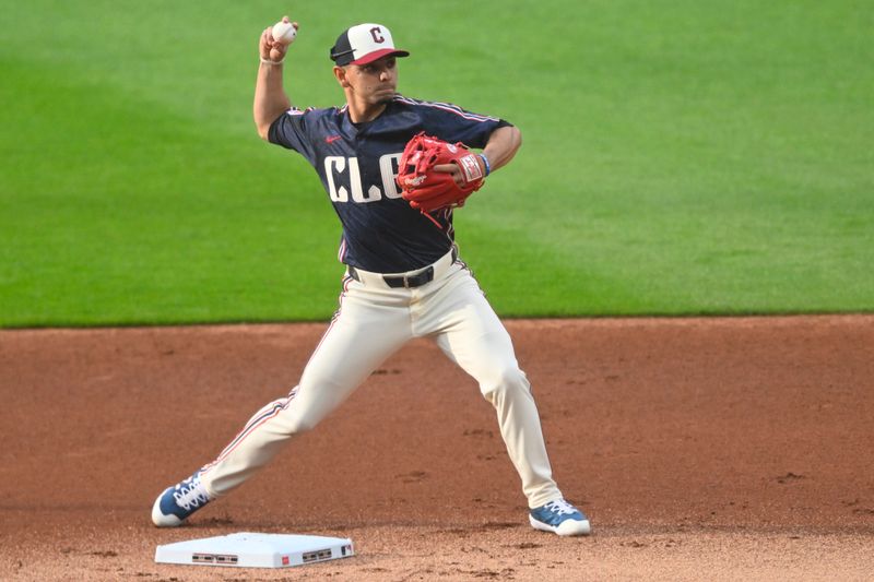 May 17, 2024; Cleveland, Ohio, USA; Cleveland Guardians second baseman Andres Gimenez (0) turns a double play in the first inning against the Minnesota Twins at Progressive Field. Mandatory Credit: David Richard-USA TODAY Sports